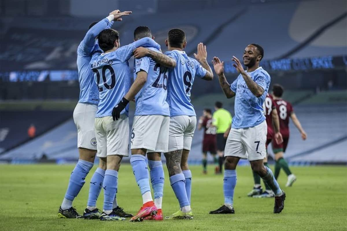 Manchester City players celebrating a goal at the Etihad stadium.