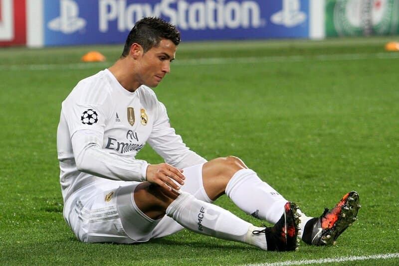 Cristiano Ronaldo sitting down on a football pitch while playing for Real Madrid.