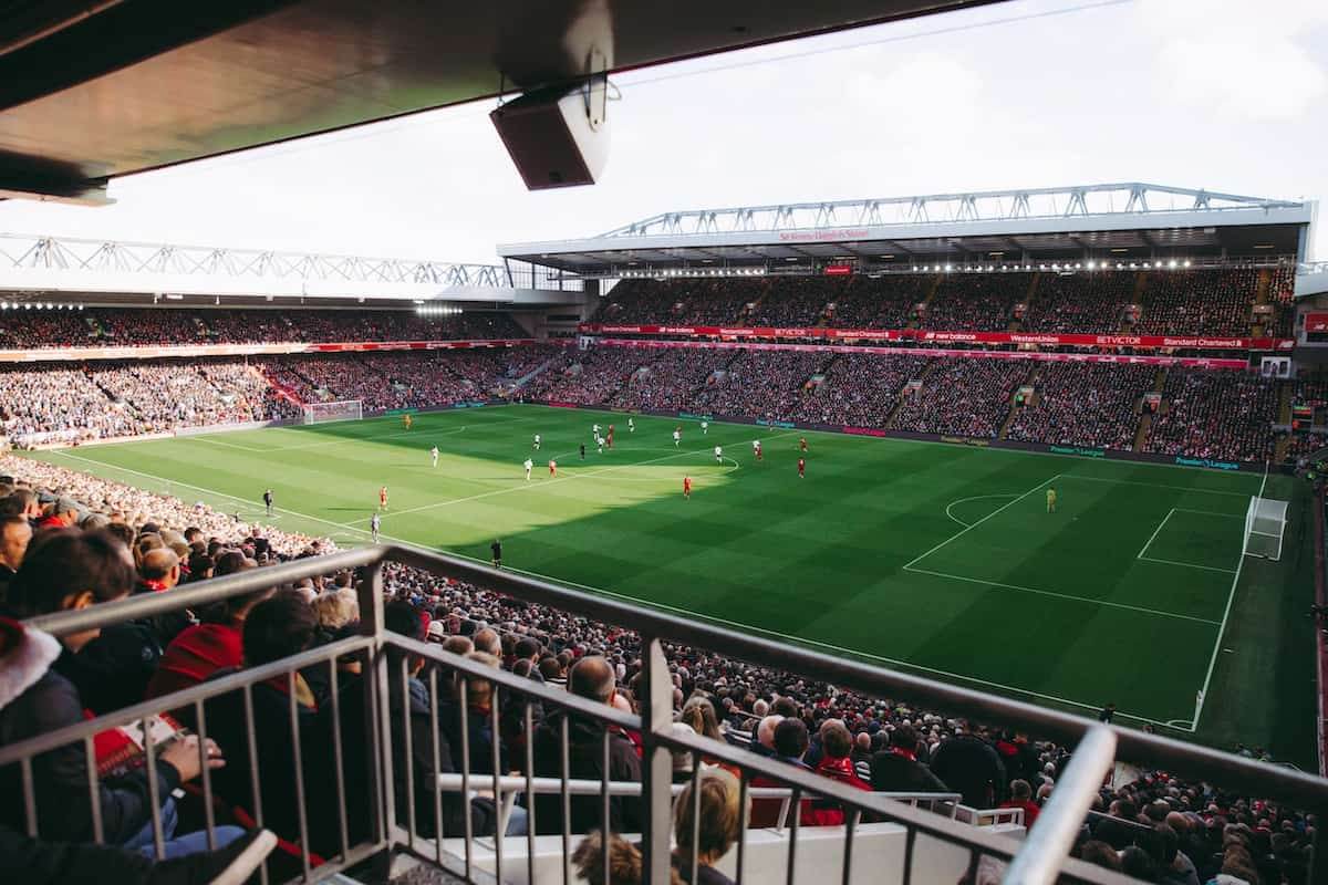 Spectators watching a football match in a stadium.