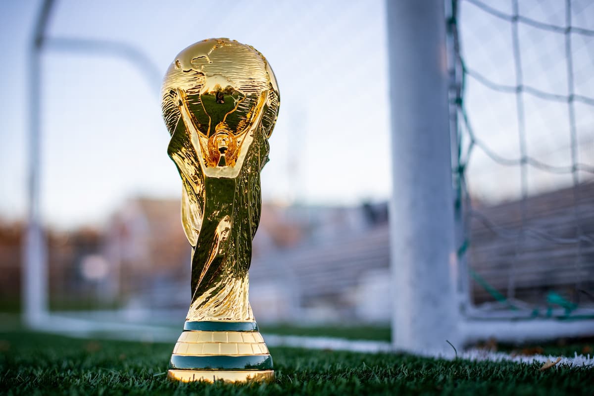 World Cup trophy in front of a goalpost.
