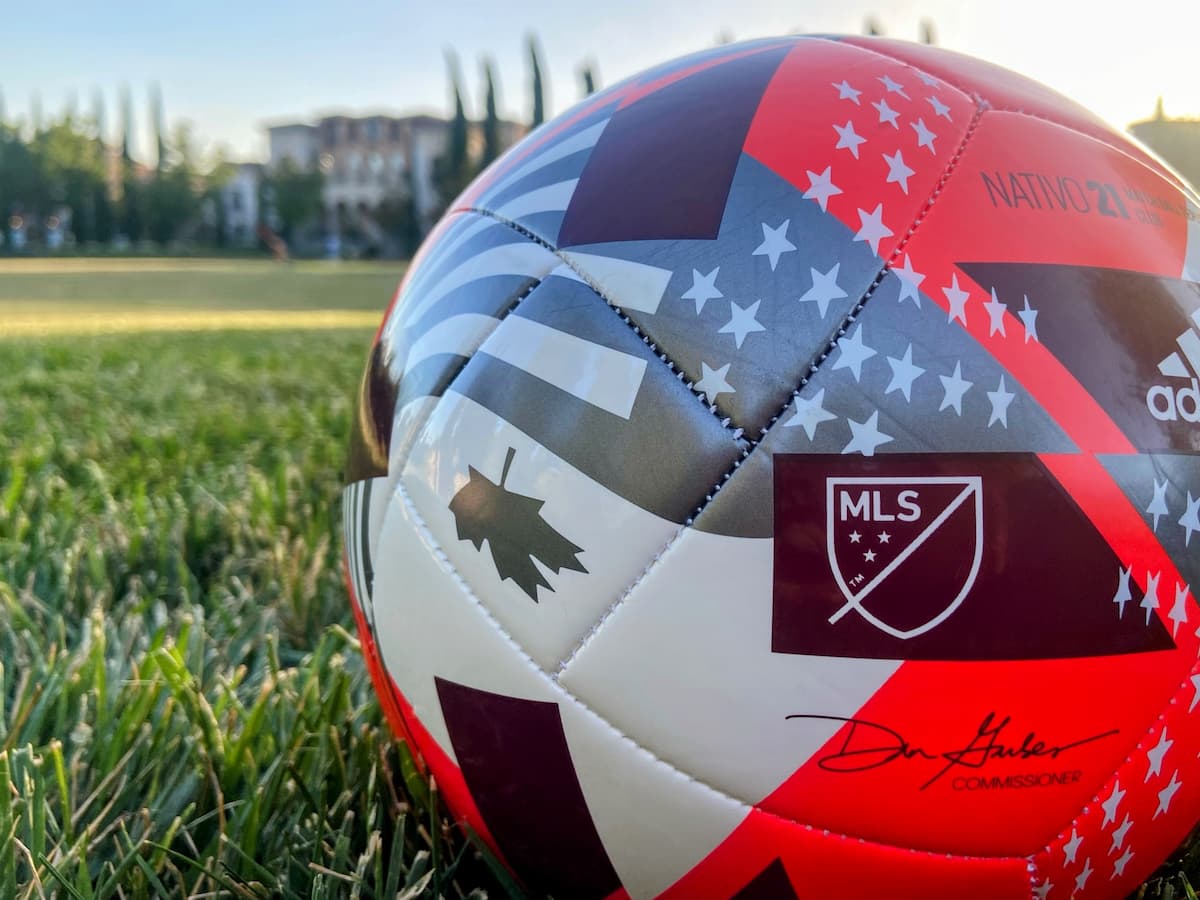 A MLS soccer ball sitting on top of a green field.