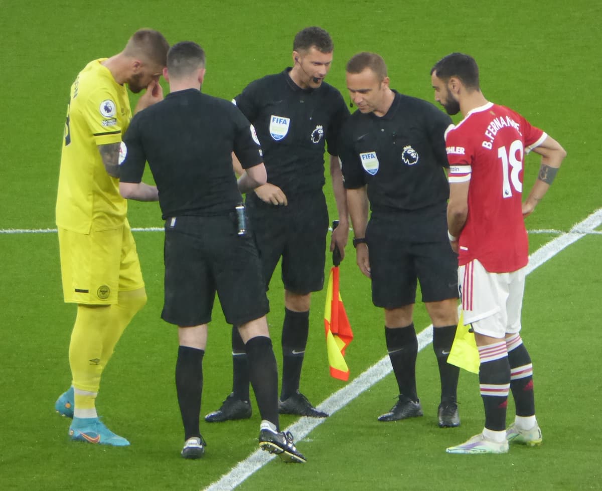 Premier League referees with Bruno Fernandes and Pontus Jansson for the coin toss before Manchester United vs Brentford in 2022.